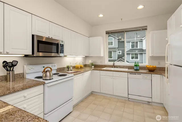 a kitchen with stainless steel appliances granite countertop a sink and a stove
