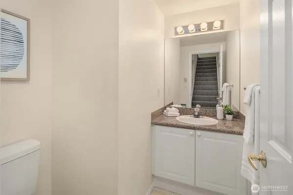 a bathroom with a granite countertop sink and a mirror