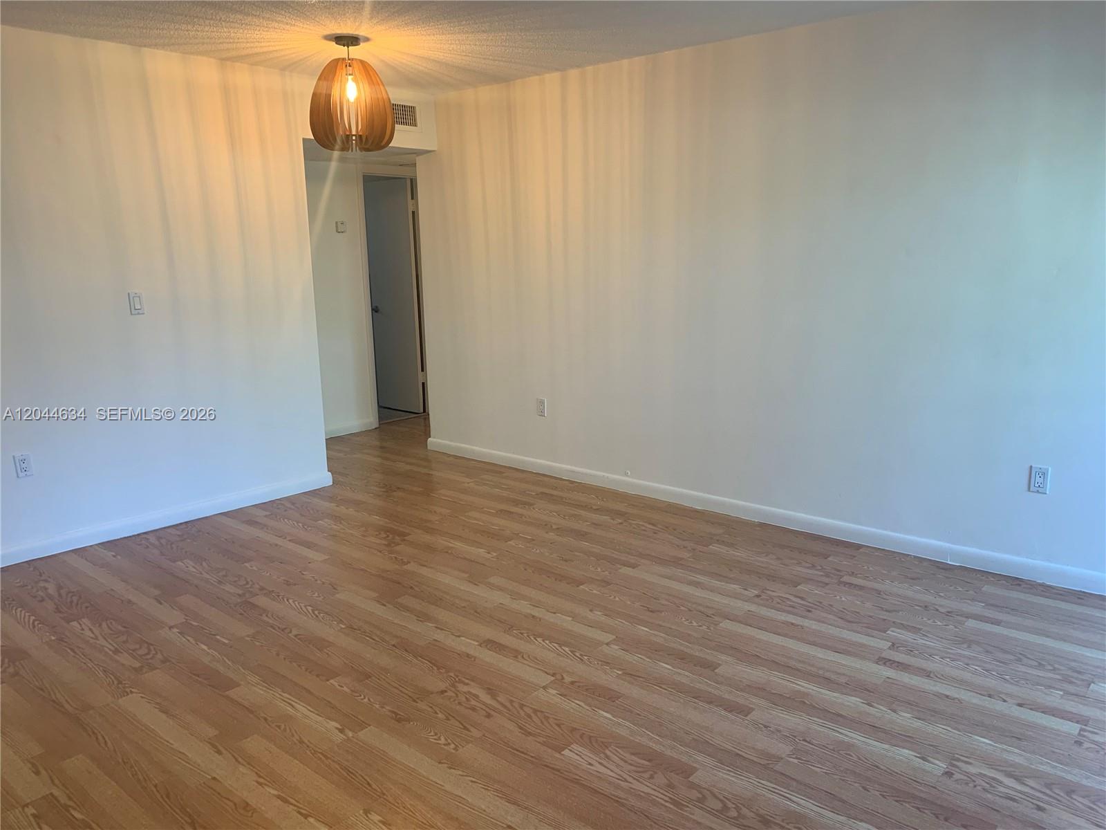 2460 Southwest 18th Avenue, Unit 1205 Miami, FL 33133 - Photo 9 of 21 a view of an empty room with wooden floor and a bathroom