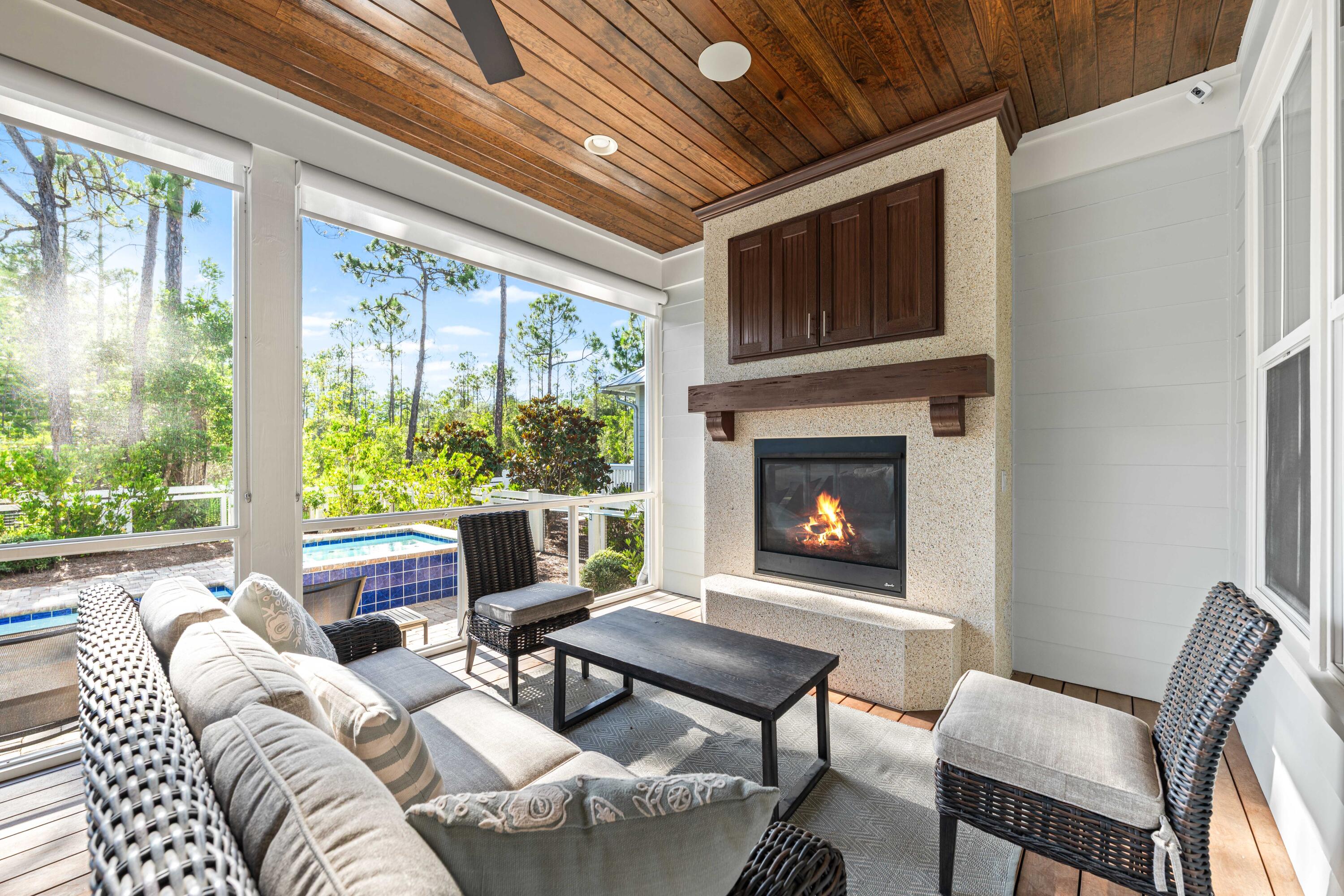 655 East Royal Fern Way Santa Rosa Beach, FL 32459 - Photo 29 of 75 a living room with furniture a fireplace and a floor to ceiling window