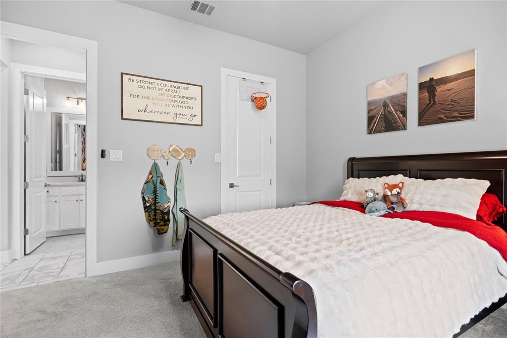 1024 Henry Way Springtown, TX 76082 - Photo 21 of 29 Bedroom featuring light gray walls, carpet flooring, and a dark wood-finish bed frame