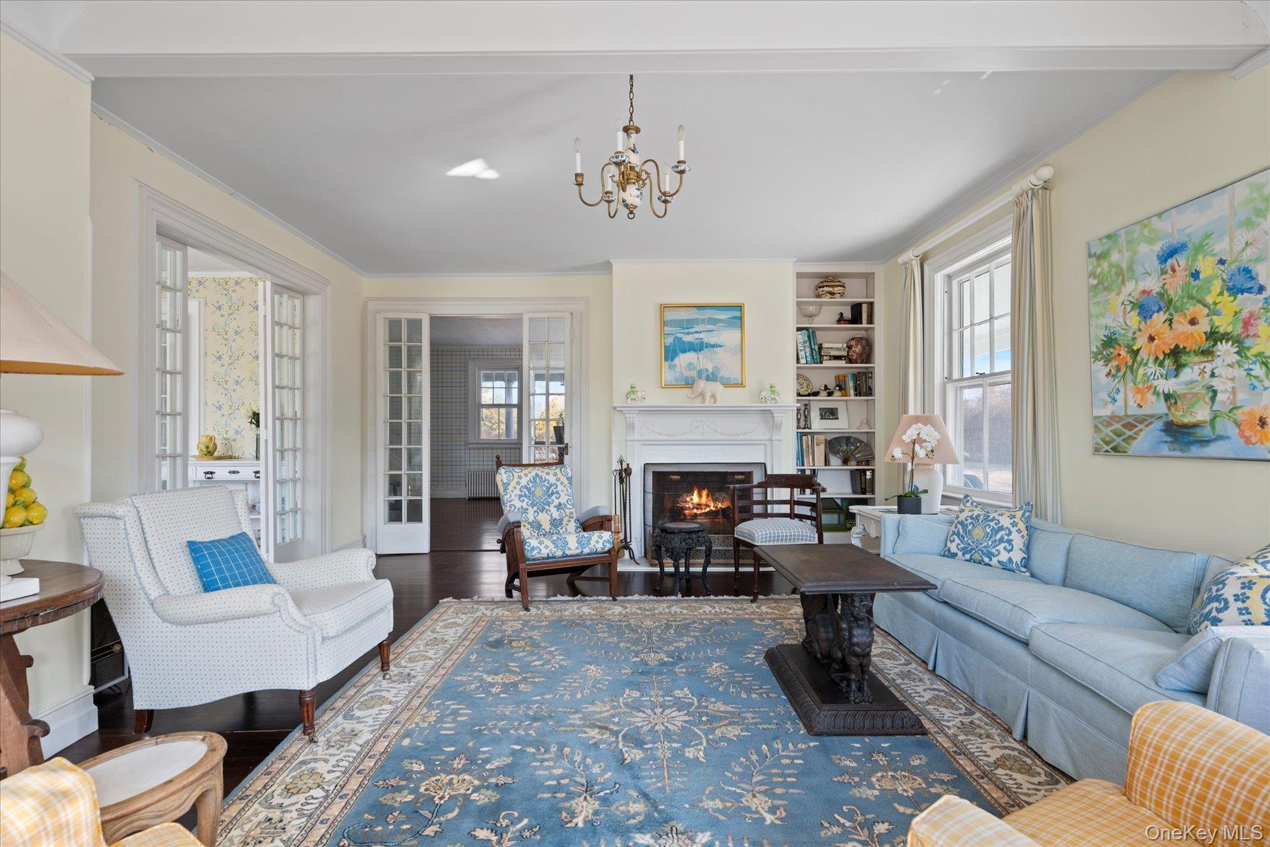 11 Shinnecock Road Quogue, NY 11959 - Photo 11 of 50 a living room with furniture a fireplace and a chandelier
