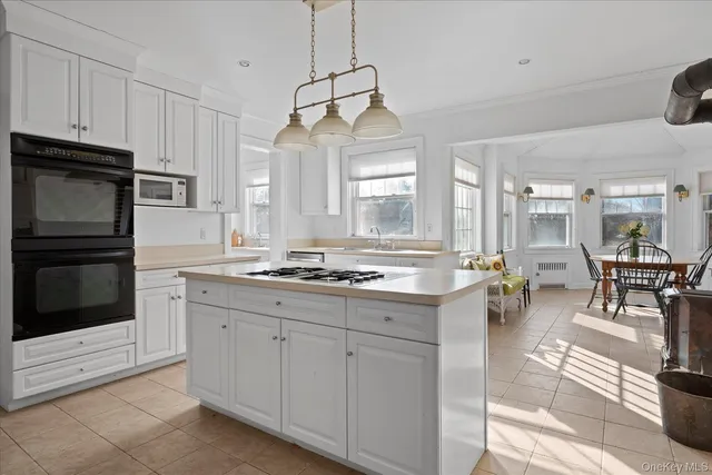 a large white kitchen with a stove and a sink