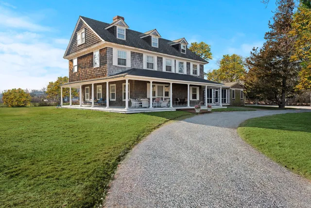 a front view of a house with a yard and potted plants