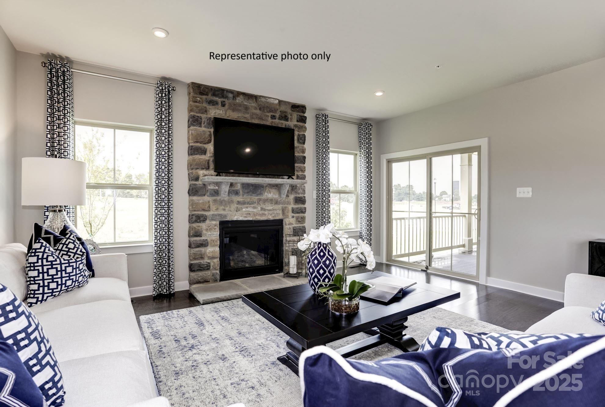 2024 Bramble Hedge Road, Unit 3241 Indian Trail, NC 28079 - Photo 4 of 11 a living room with furniture a flat screen tv and a fireplace