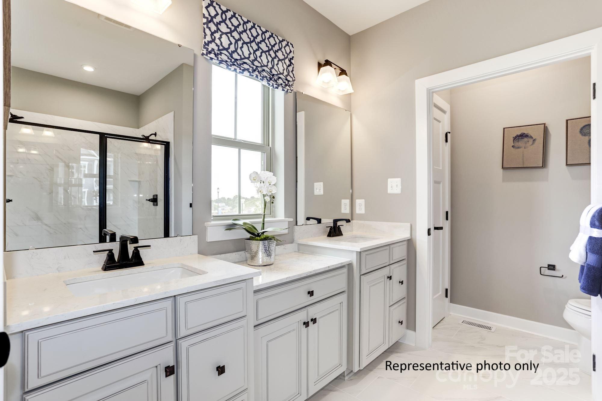 2024 Bramble Hedge Road, Unit 3241 Indian Trail, NC 28079 - Photo 8 of 11 a spacious bathroom with a double vanity sink a mirror and a bathtub