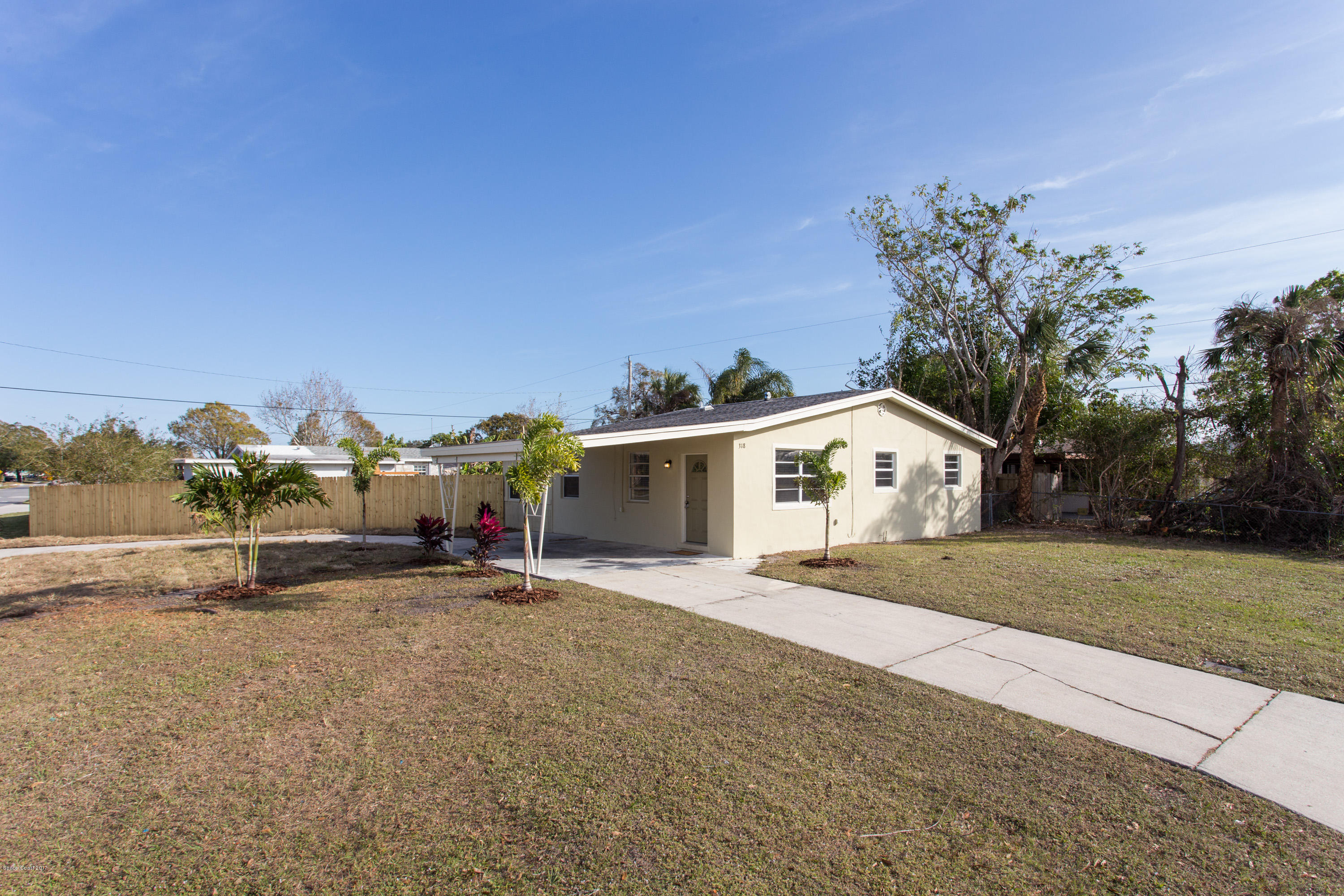 318 West Rutgers Street Melbourne, FL 32901 - Photo 2 of 14 a view of a house with a yard and large trees