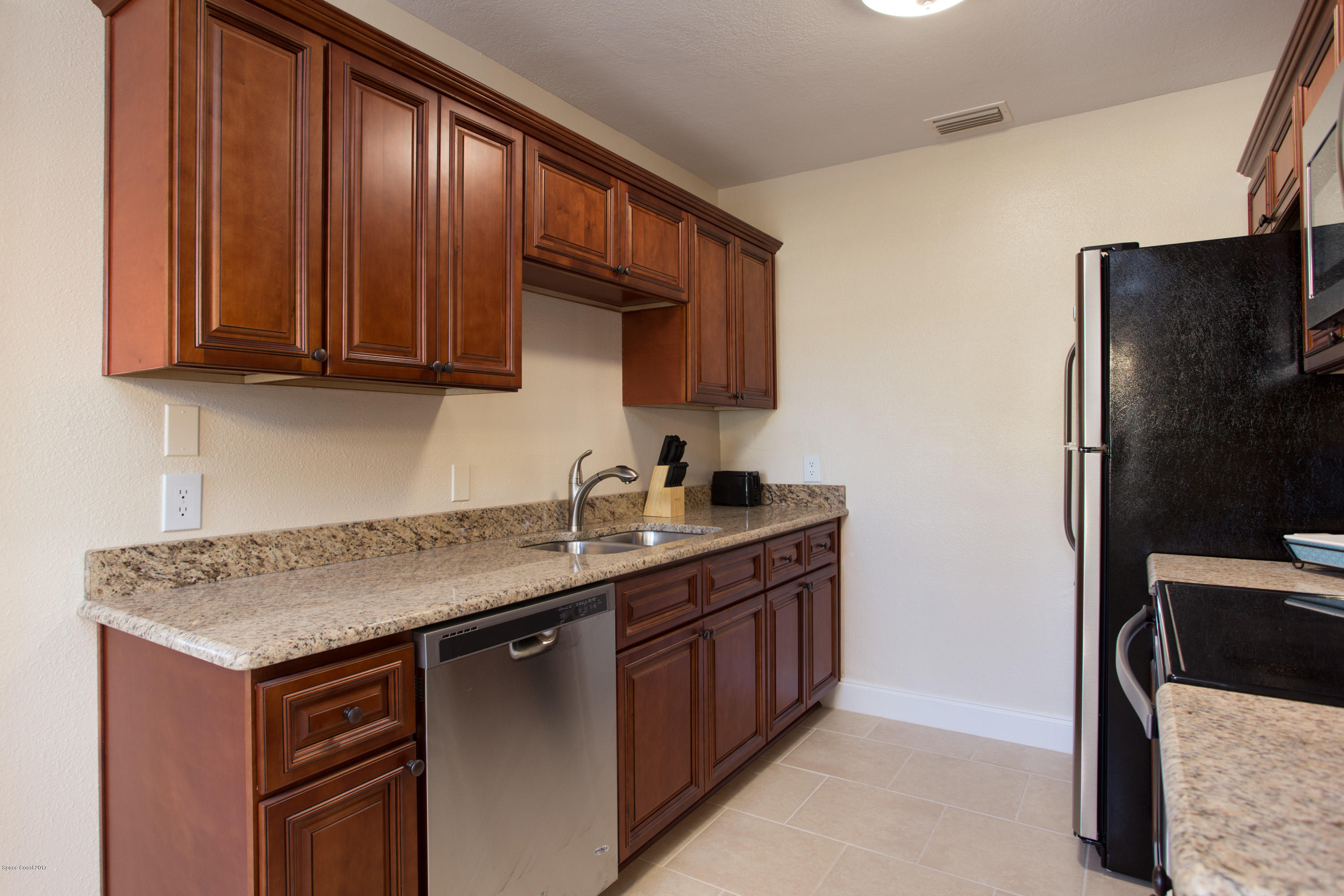 318 West Rutgers Street Melbourne, FL 32901 - Photo 6 of 14 a kitchen with stainless steel appliances granite countertop a sink stove and refrigerator