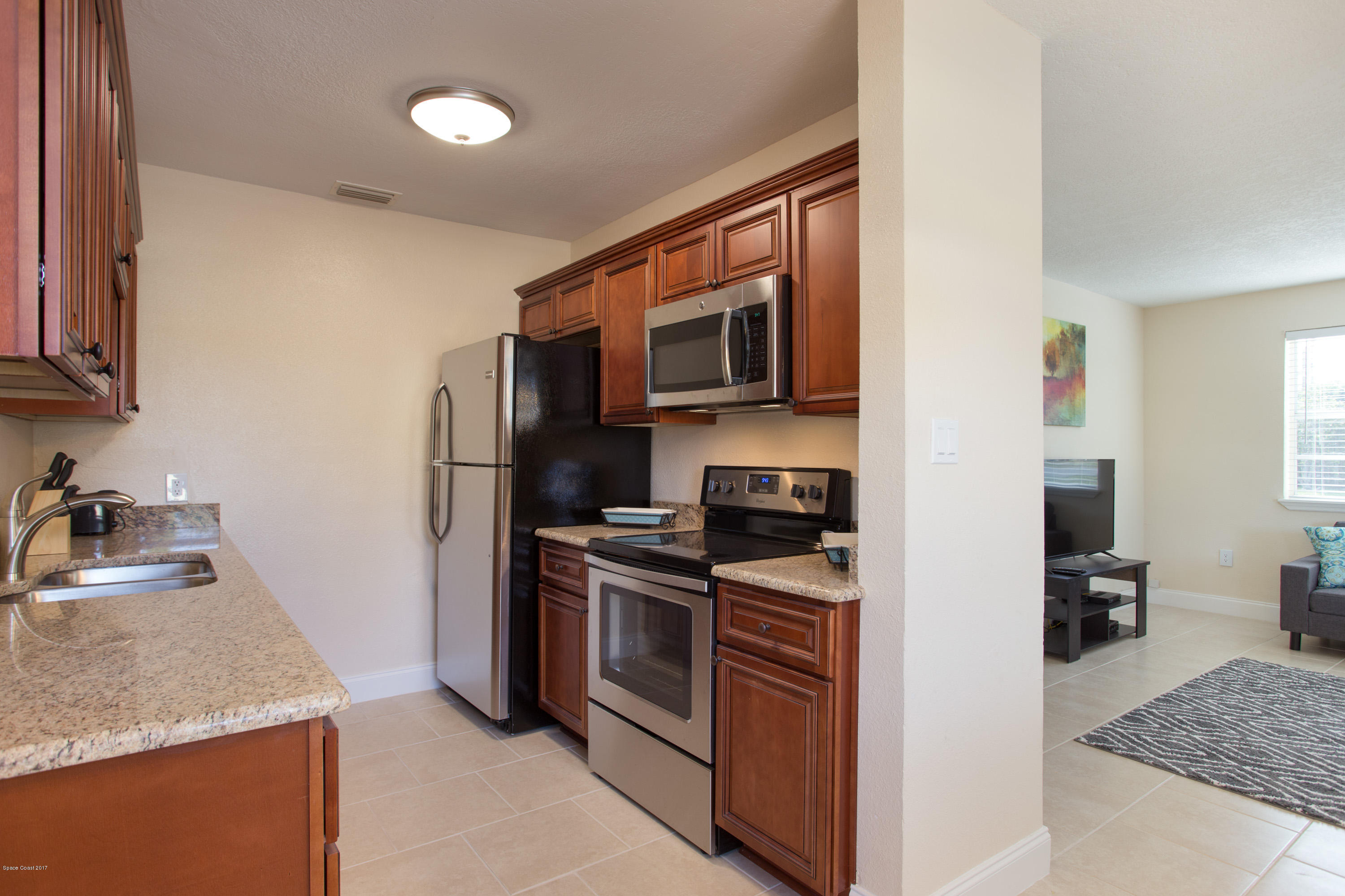 318 West Rutgers Street Melbourne, FL 32901 - Photo 7 of 14 a kitchen with stainless steel appliances granite countertop a sink stove and refrigerator