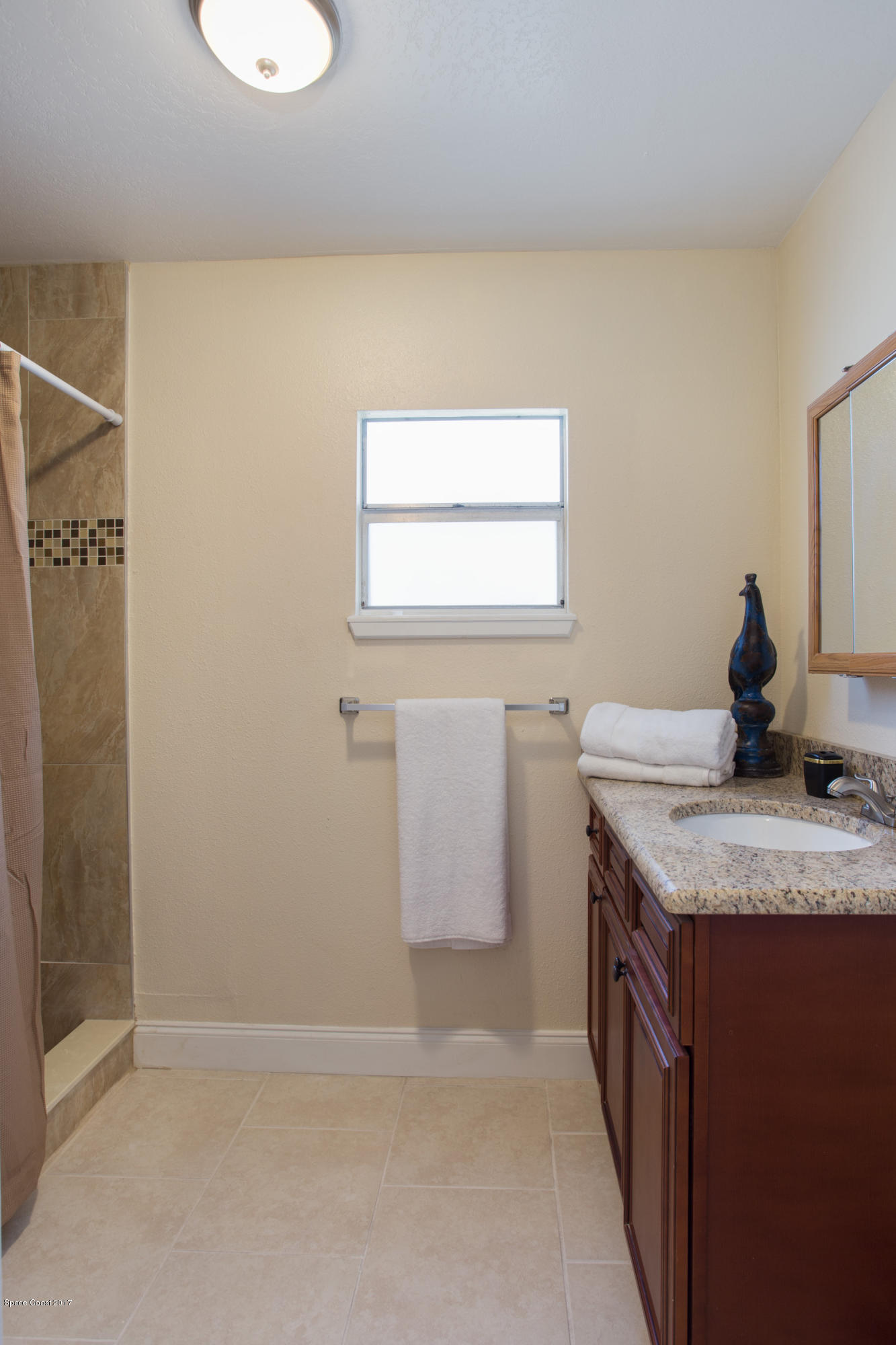 318 West Rutgers Street Melbourne, FL 32901 - Photo 10 of 14 a bathroom with a granite countertop sink a toilet and mirror