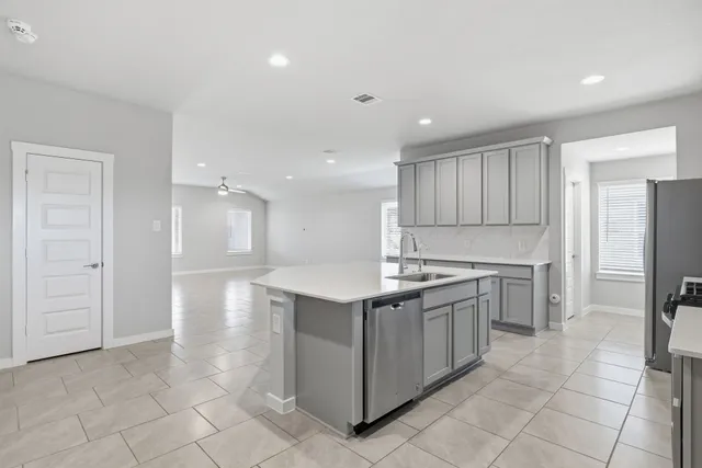 a kitchen with a sink a refrigerator and cabinets