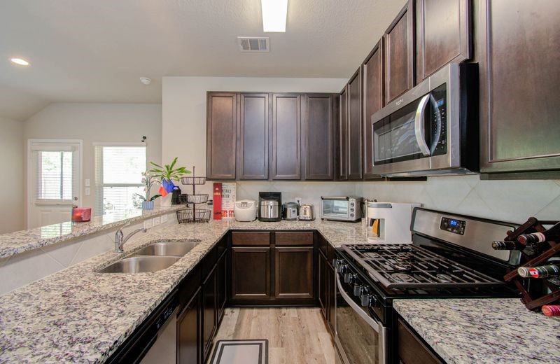 25416 Grotto Falls Lane Porter, TX 77365 - Photo 3 of 15 a kitchen with stainless steel appliances granite countertop a sink stove and cabinets