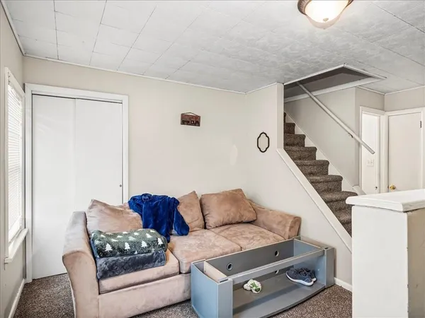 a living room with furniture and a painting on the wall