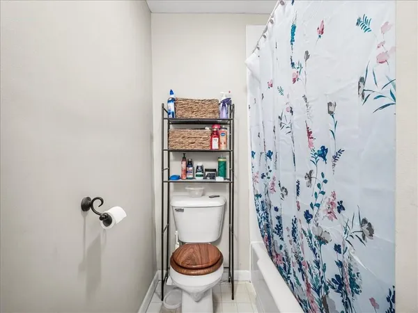 a bathroom with a toilet and a shower curtain