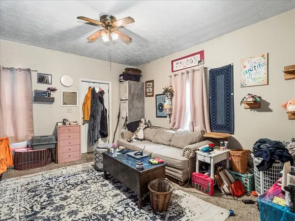 a living room with furniture a rug and white walls