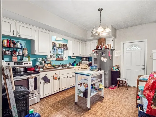 a kitchen that has a lot of cabinets a sink and appliances in it