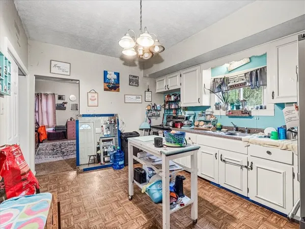 a room with a white furniture a chandelier and a window