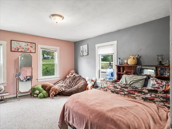 a bedroom with two beds and windows