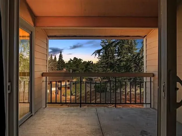a view of a balcony with a floor to ceiling window and wooden floor