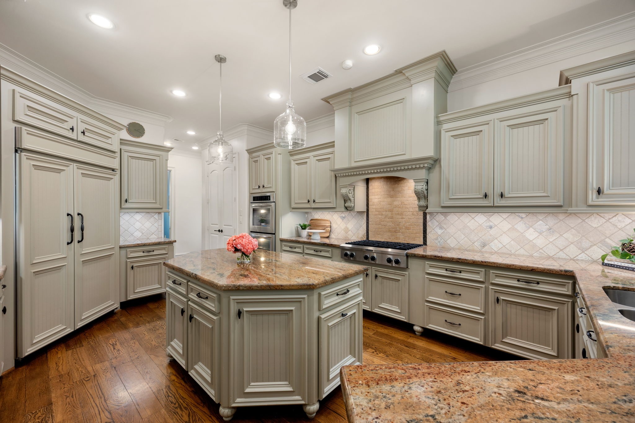 The chef's kitchen is open to the breakfast area and the living room and has a large kitchen island, paneled appliances and is perfect for entertaining. Appliances are Kitchenaid and Bosch and includes double ovens and a 6 burner gas cooktop.