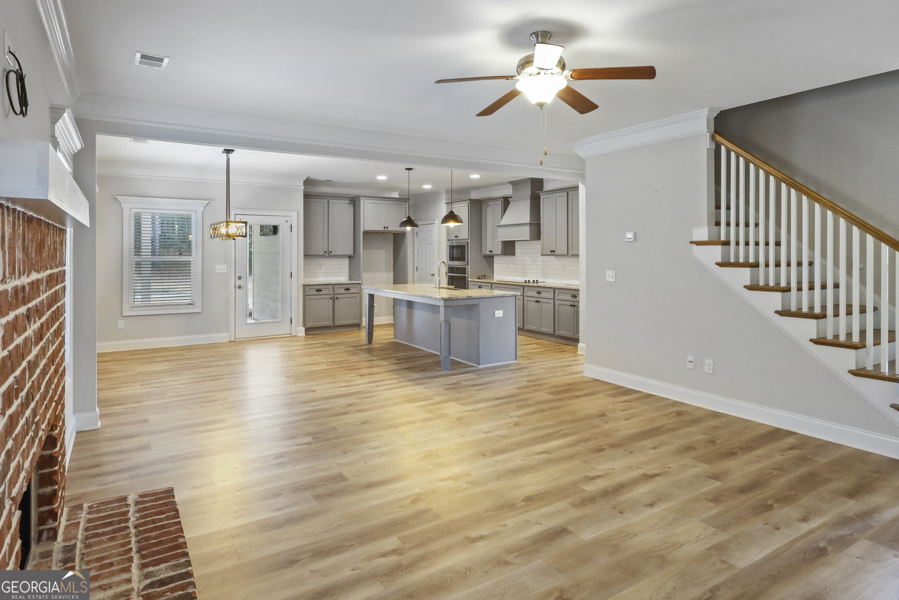 563 Wynn Road McDonough, GA 30252 - Photo 11 of 47 a view of a living room a kitchen island with wooden floor and a fireplace