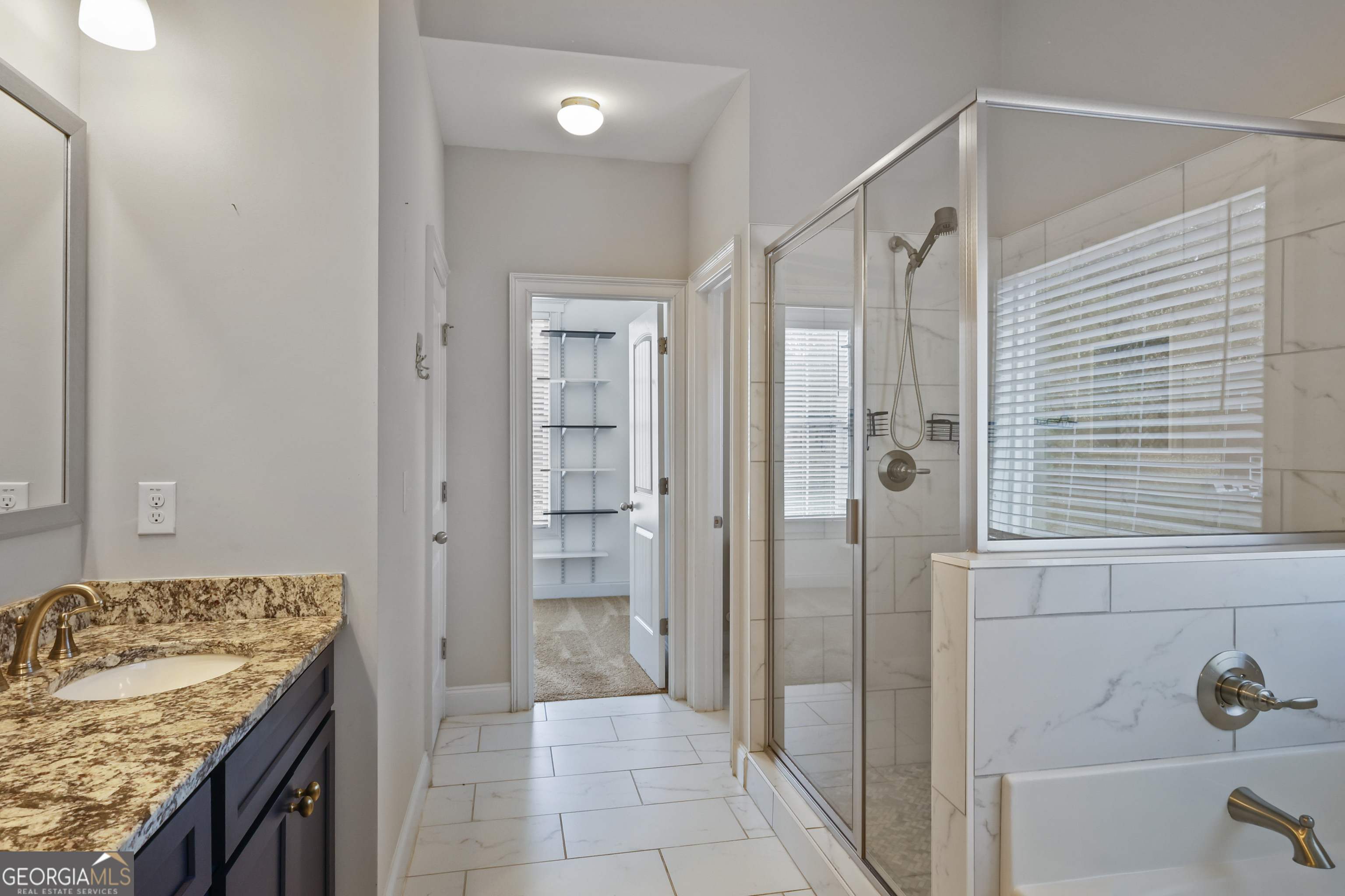 563 Wynn Road McDonough, GA 30252 - Photo 19 of 47 a bathroom with a granite countertop sink a mirror and shower