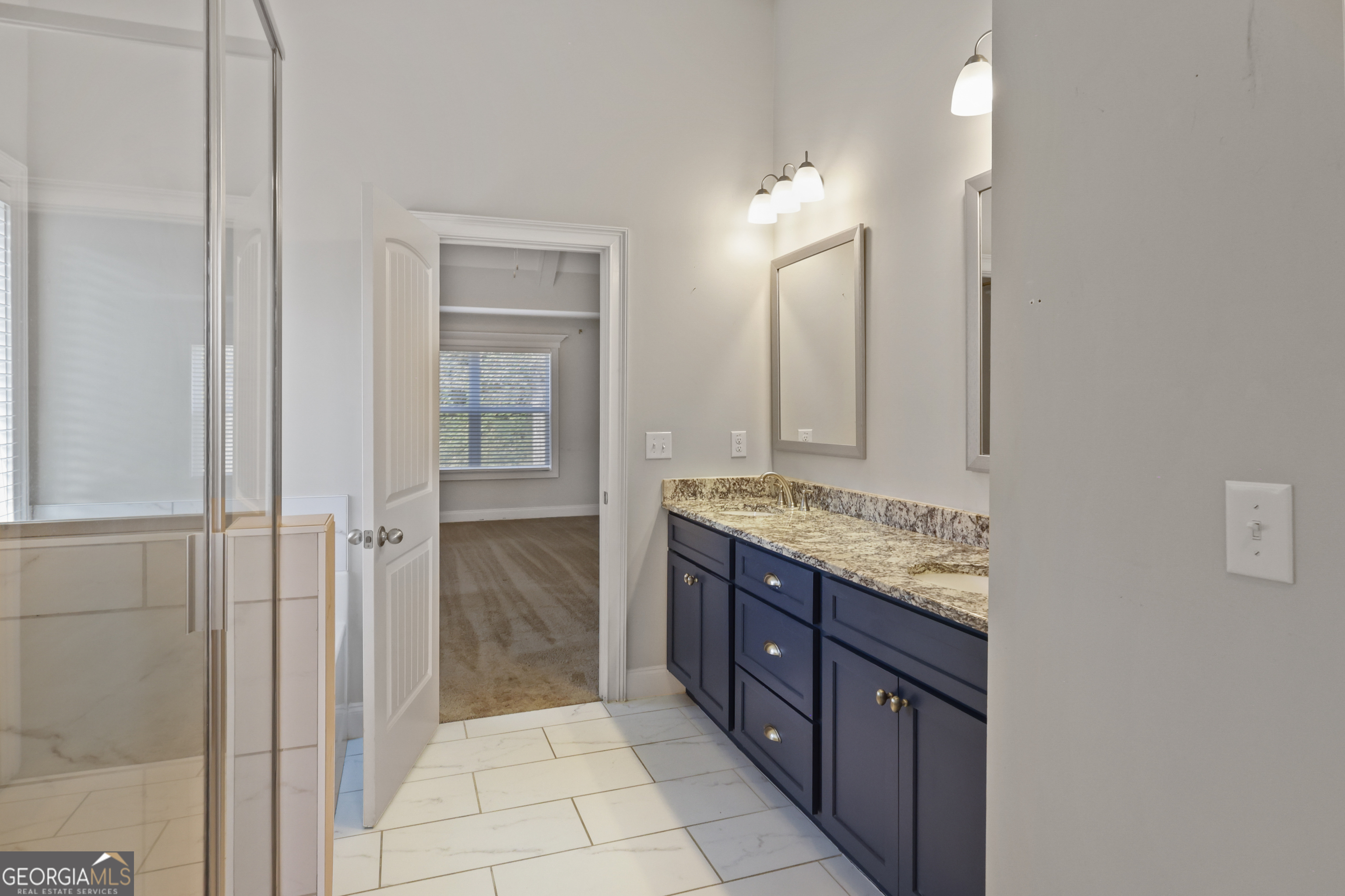 563 Wynn Road McDonough, GA 30252 - Photo 20 of 47 a bathroom with a granite countertop sink a mirror and a shower