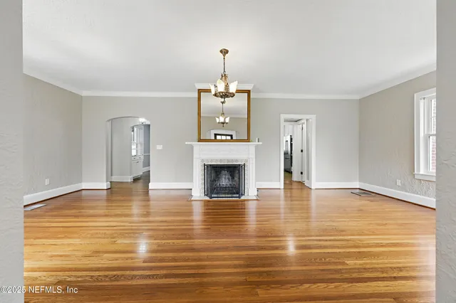 a living room with furniture couches and a dining table with wooden floor
