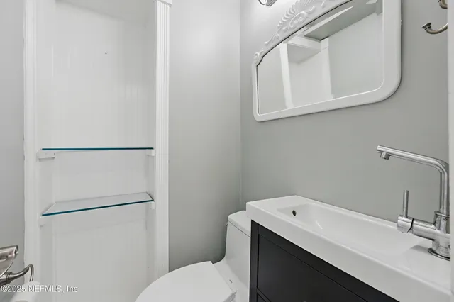 a bathroom with a sink a toilet and mirror