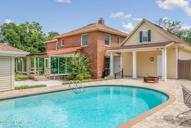 a view of a livingroom with a fireplace a chandelier and wooden floor