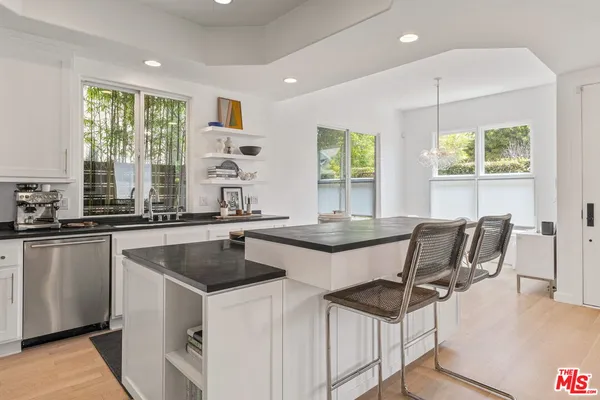 a kitchen with a table chairs sink and cabinets