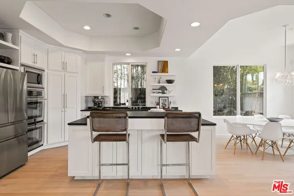 a kitchen with a dining table chairs and refrigerator