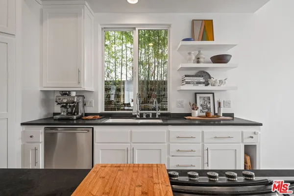 a kitchen with granite countertop a sink and a stove
