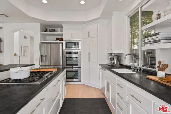 a kitchen with stainless steel appliances granite countertop a sink stove and refrigerator