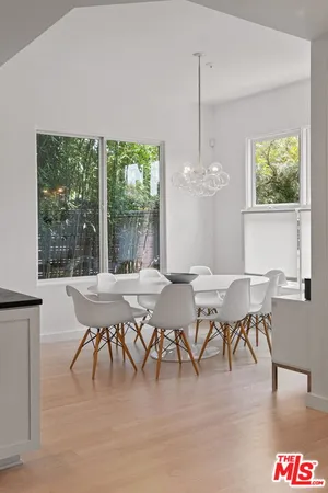 a dining room with furniture a chandelier and wooden floor