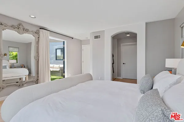 a bedroom with a bed and a mirror