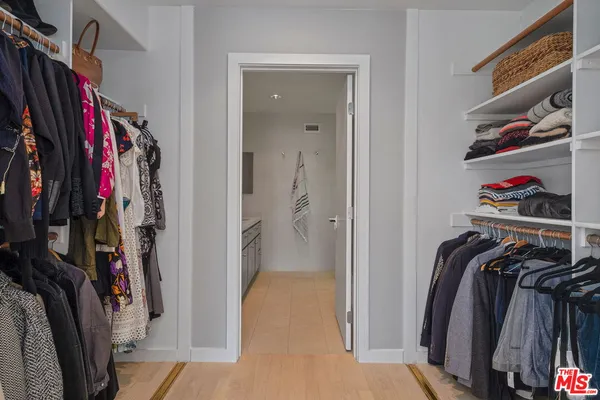 a view of walk in closet with clothes and shoes