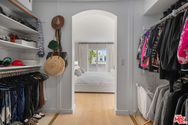 a view of walk in closet with clothes and shoes