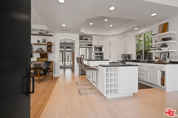 a kitchen with stainless steel appliances kitchen island granite countertop a stove a sink and a refrigerator