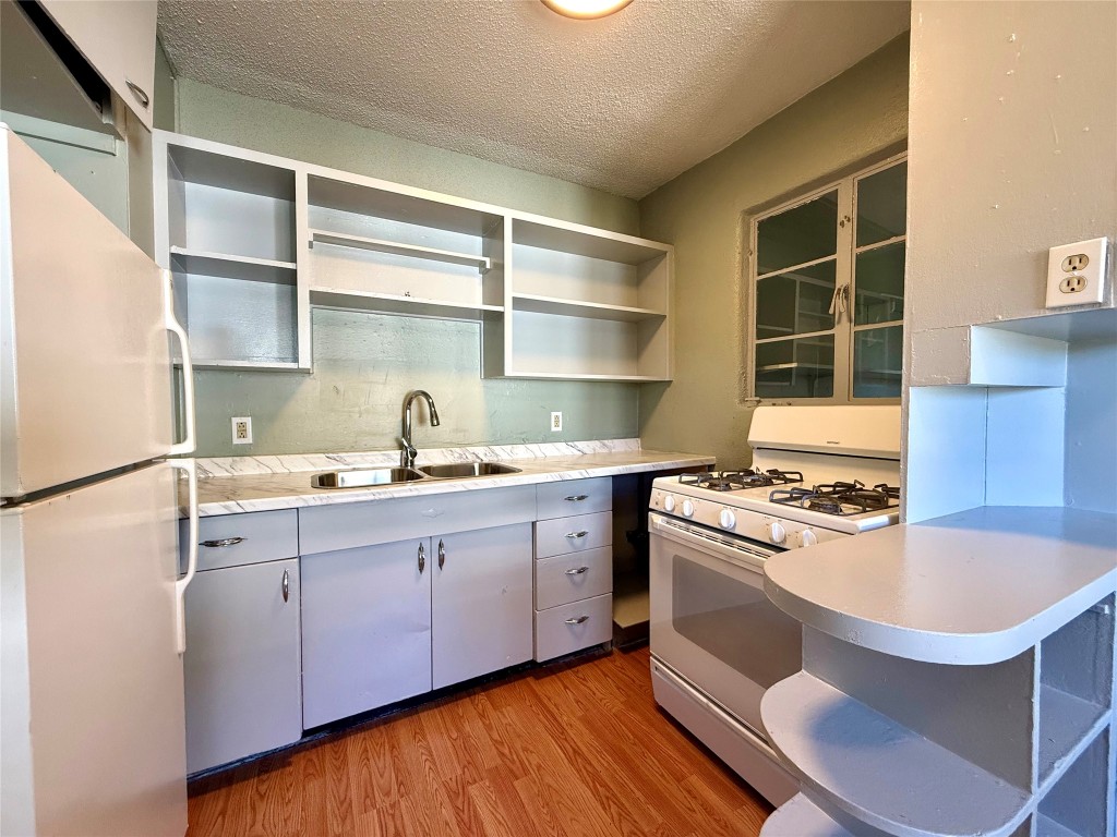 3702 Werner Avenue Austin, TX 78722 - Photo 6 of 20 a kitchen with a stove a sink and a refrigerator