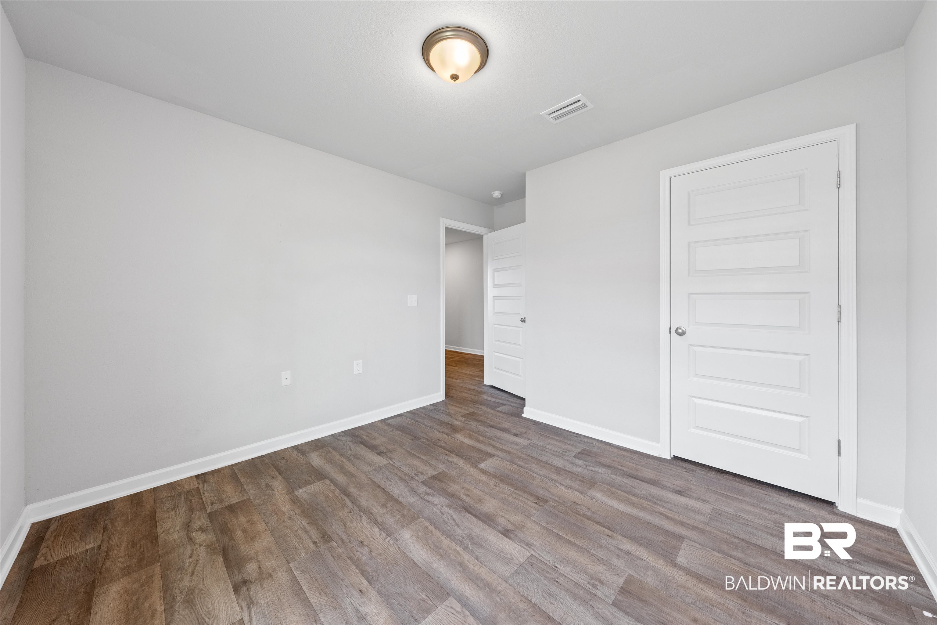 7457 Brompton Drive Foley, AL 36535 - Photo 20 of 24 Unfurnished bedroom featuring baseboards and dark wood-style flooring