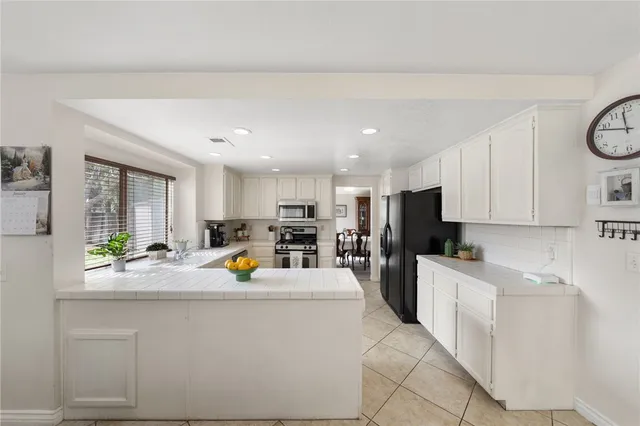 a kitchen view with living furniture a sink a stove and a refrigerator