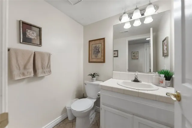 a bathroom with a sink vanity granite and toilet