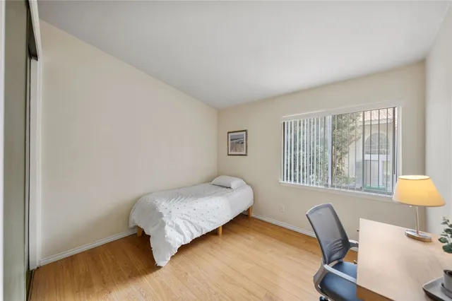 a bedroom with a bed and wooden floor