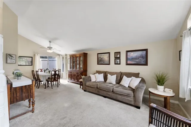 a living room with furniture and a dining table with wooden floor