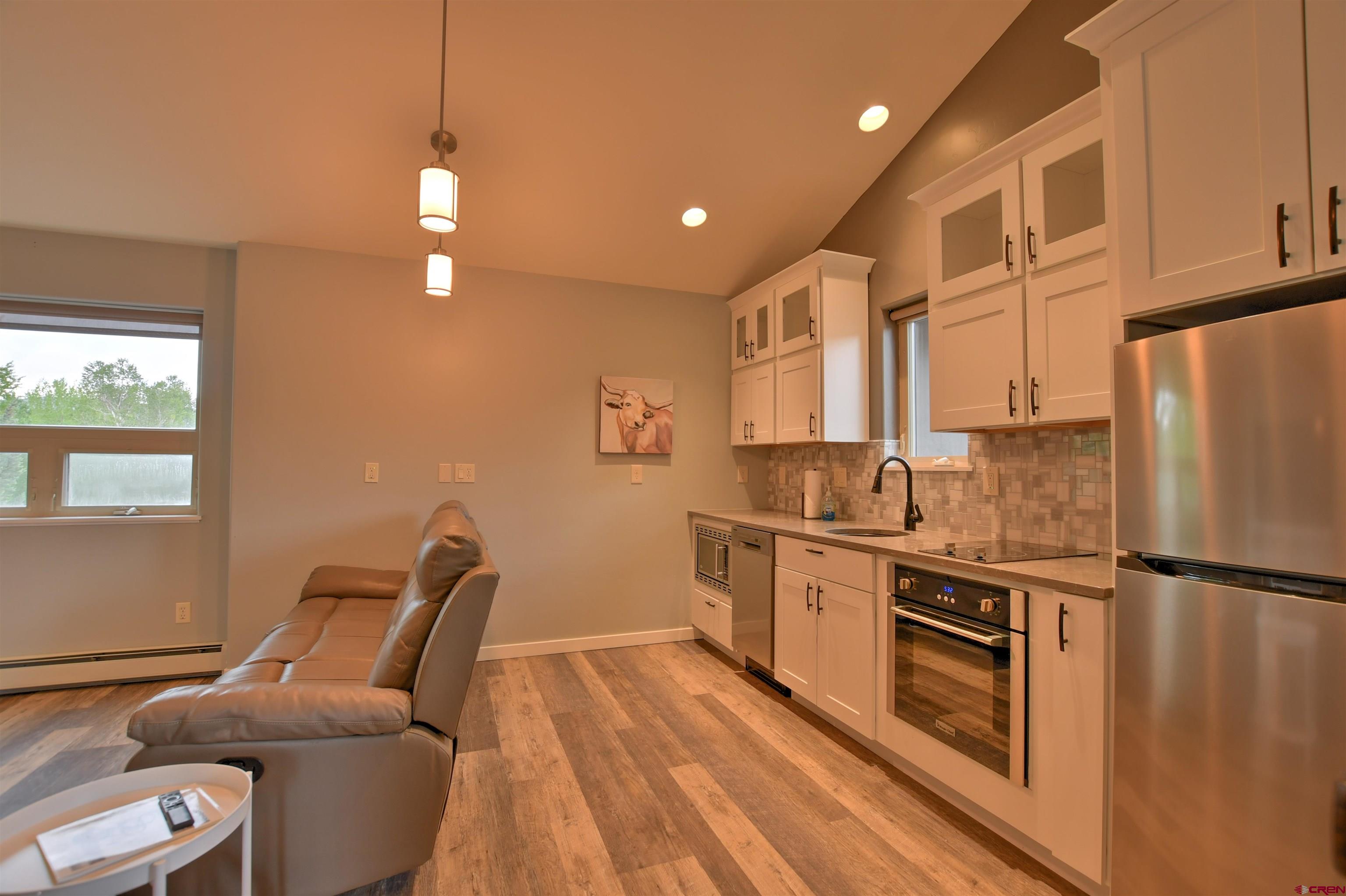 602 Chipeta Drive Ridgway, CO 81432 - Photo 17 of 41 a kitchen with stainless steel appliances granite countertop a refrigerator a sink dishwasher a stove and white countertops with wooden floor