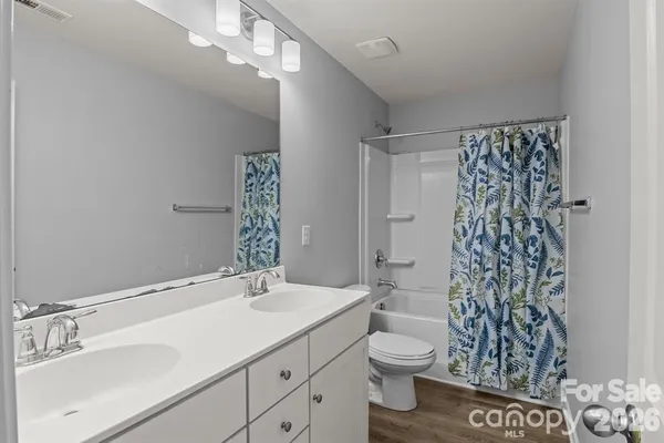 a bathroom with a sink a toilet and shower curtain