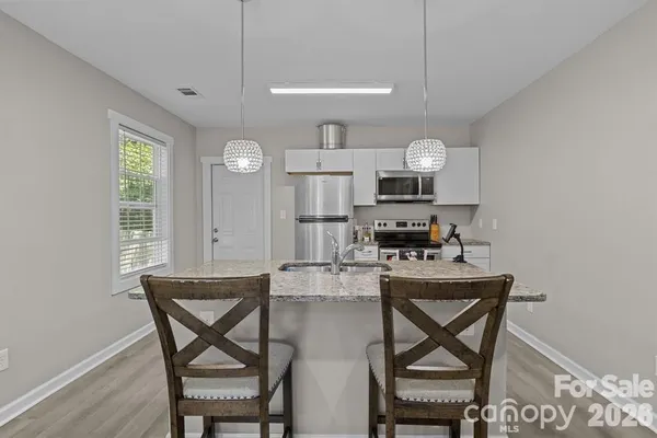 a kitchen with kitchen island white cabinets and stainless steel appliances