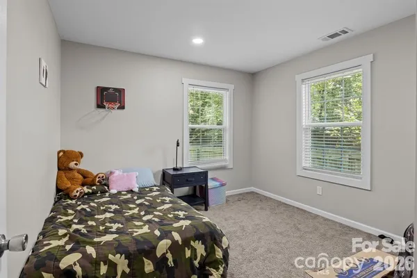 a bed sitting in a bedroom next to a window