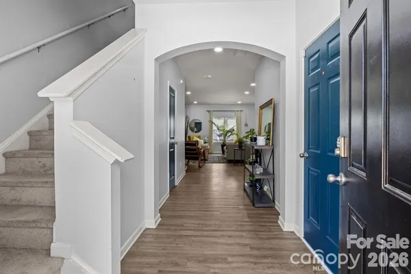 a view of a hallway view with living room and wooden floor